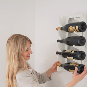 Væghængt vinreol, hvid. Kvinde sætter vin på plads