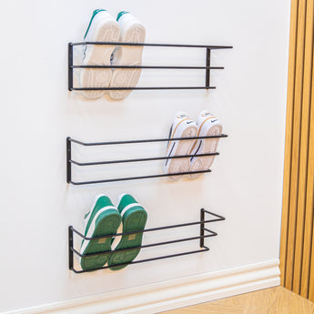 Sort væghængt Nohr skohylde med tre hylder, der sparer plads i entreen.